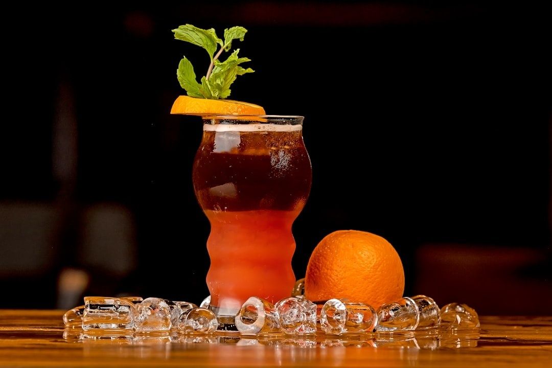 Alkoholfreier Drink mit Orange, Minze und Eiswürfeln an einer Bar