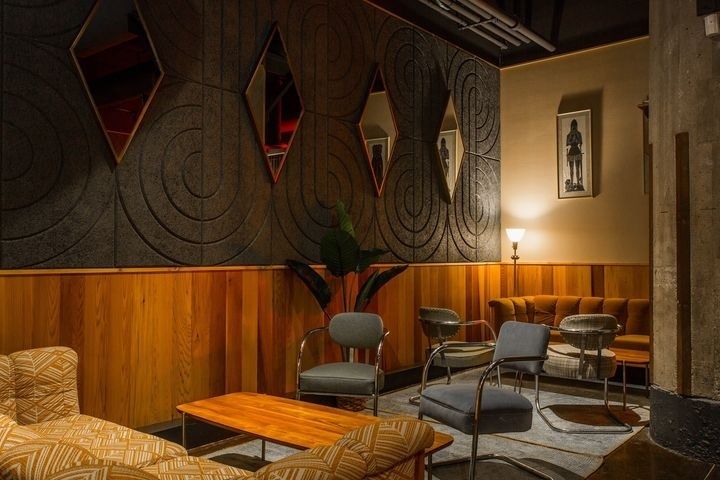 Gedämpfte Bar-Lounge mit Holzverkleidung und strukturierten Wandflächen